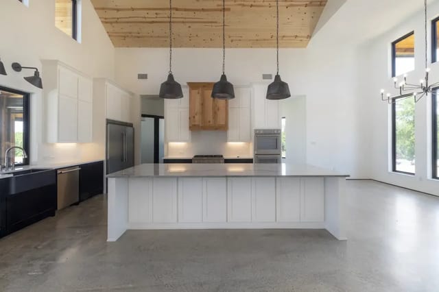 Cream-polished floor with no aggregate exposure, showcasing smooth, variegated finish in new residential construction Cream-polished concrete floor in modern kitchen with natural surface variations and seamless finish